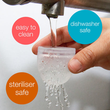 Eclectic B.Box silicone food feeder pouch being rinsed under a tap, highlighting dishwasher and steriliser safety.