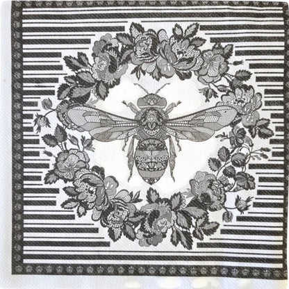 Eclectic Bee Black disposable napkin featuring an intricate bee and floral wreath motif with a graphic linear border.