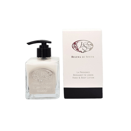 Eclectic Bergamot & Lemon hand and body lotion in a square glass pump bottle next to its elegant white and black box.