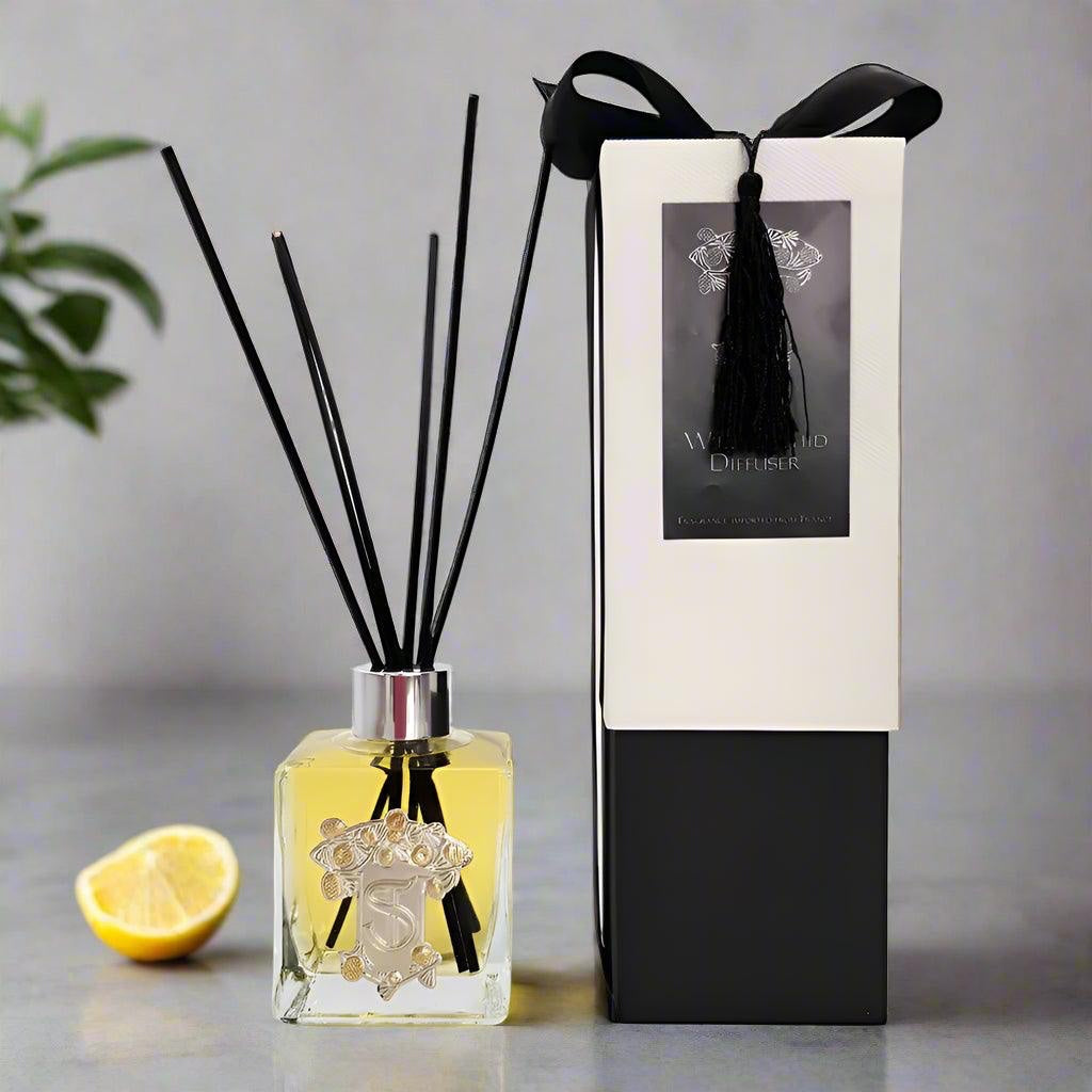 Eclectic Bergamot and Lemon reed diffuser in a square glass bottle with a pewter emblem and black gift box.