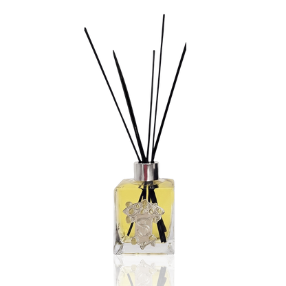 Eclectic Bergamot & Lemon reed diffuser in a square glass bottle with a pewter-style emblem and black reeds.