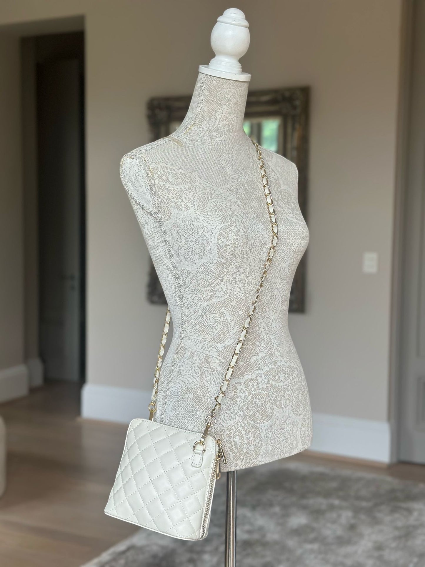 Eclectic Bianca cream quilted leather crossbody bag with gold-tone chain strap displayed on a mannequin