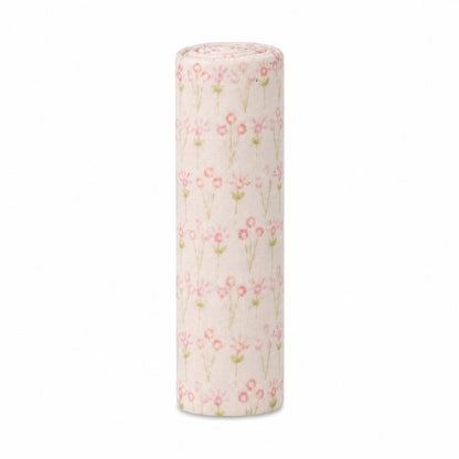 Eclectic Biddykins Bloom cotton flannel baby blanket rolled up with a soft pink floral print on a white background.