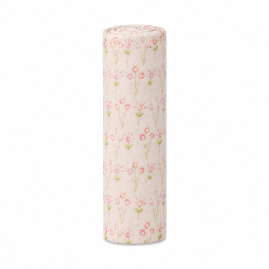 Eclectic Biddykins Bloom cotton flannel baby blanket rolled up with a soft pink floral print on a white background.