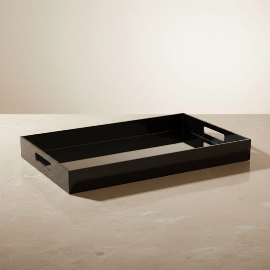 Eclectic modern rectangular black acrylic serving tray with a mirrored base and integrated handles on a stone surface.