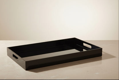 Eclectic black acrylic serving tray with integrated handles on a neutral surface for modern home decor styling.