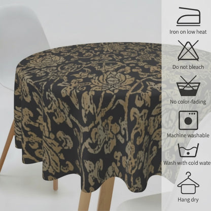 Eclectic round black and gold baroque tablecloth draped over a table with care instruction icons displayed on the side.