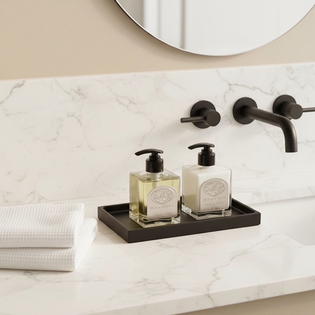 Eclectic minimalist black silicone vanity tray holding soap and lotion bottles on a marble bathroom counter.