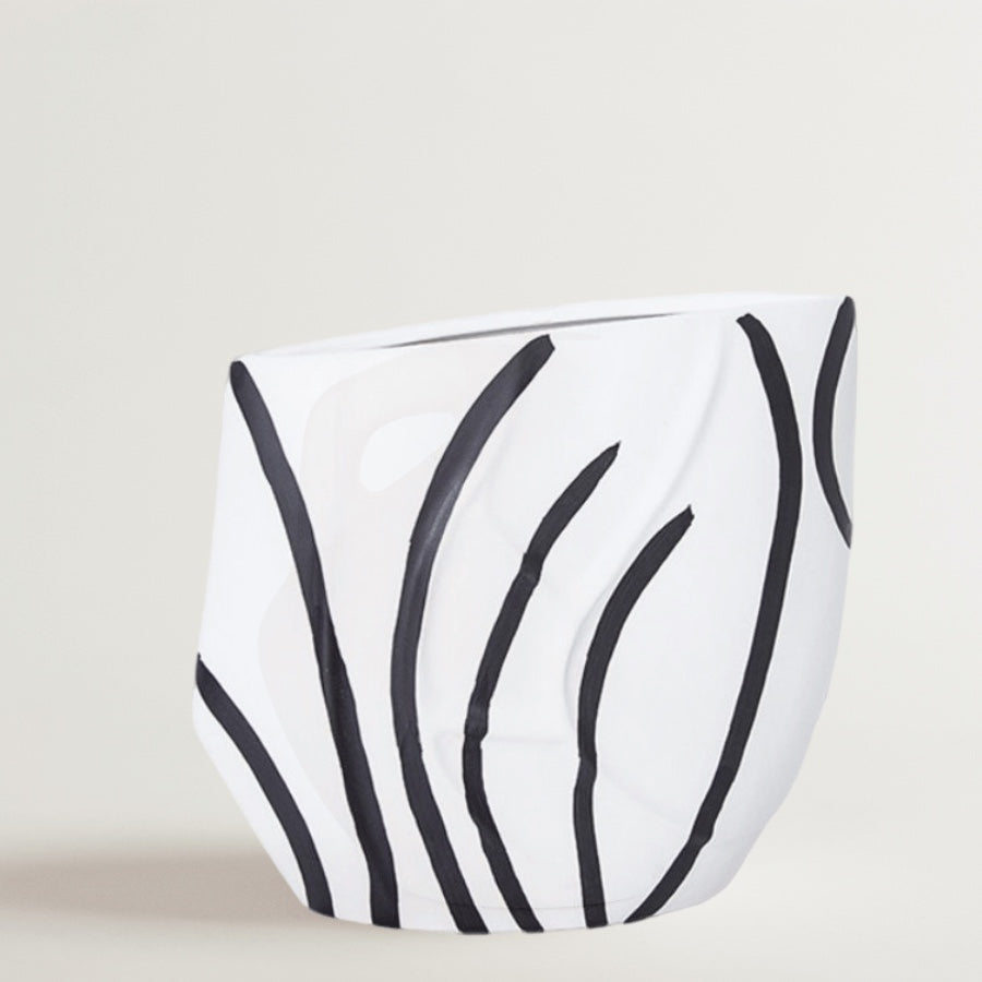 Eclectic black and white ceramic vase with a curved silhouette and hand-painted reed pattern in a high-gloss finish.