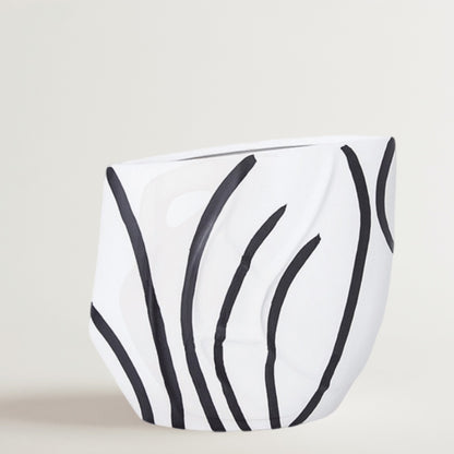 Eclectic black and white ceramic vase with a curved silhouette and hand-painted reed pattern in a high-gloss finish.
