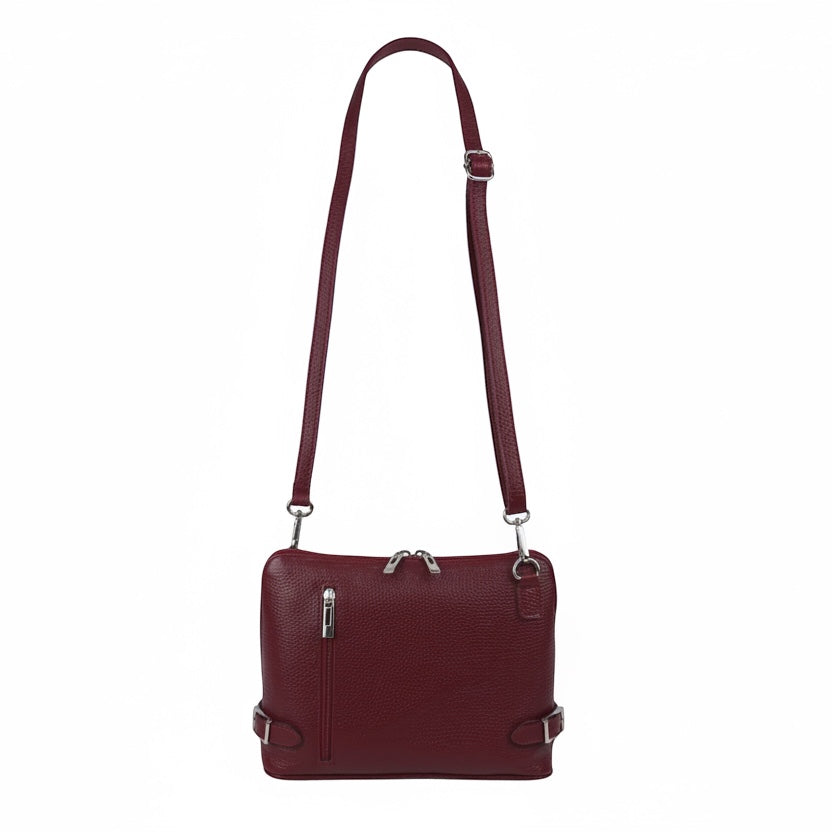Eclectic burgundy grained Italian leather crossbody bag with silver hardware and side buckle details.