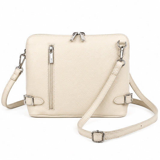 Eclectic Capri cream grained leather crossbody bag with silver hardware, side buckles, and front zip pocket.