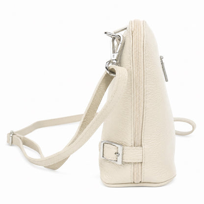 Eclectic Capri cream grained leather crossbody bag with silver hardware and side buckle detail, side view.