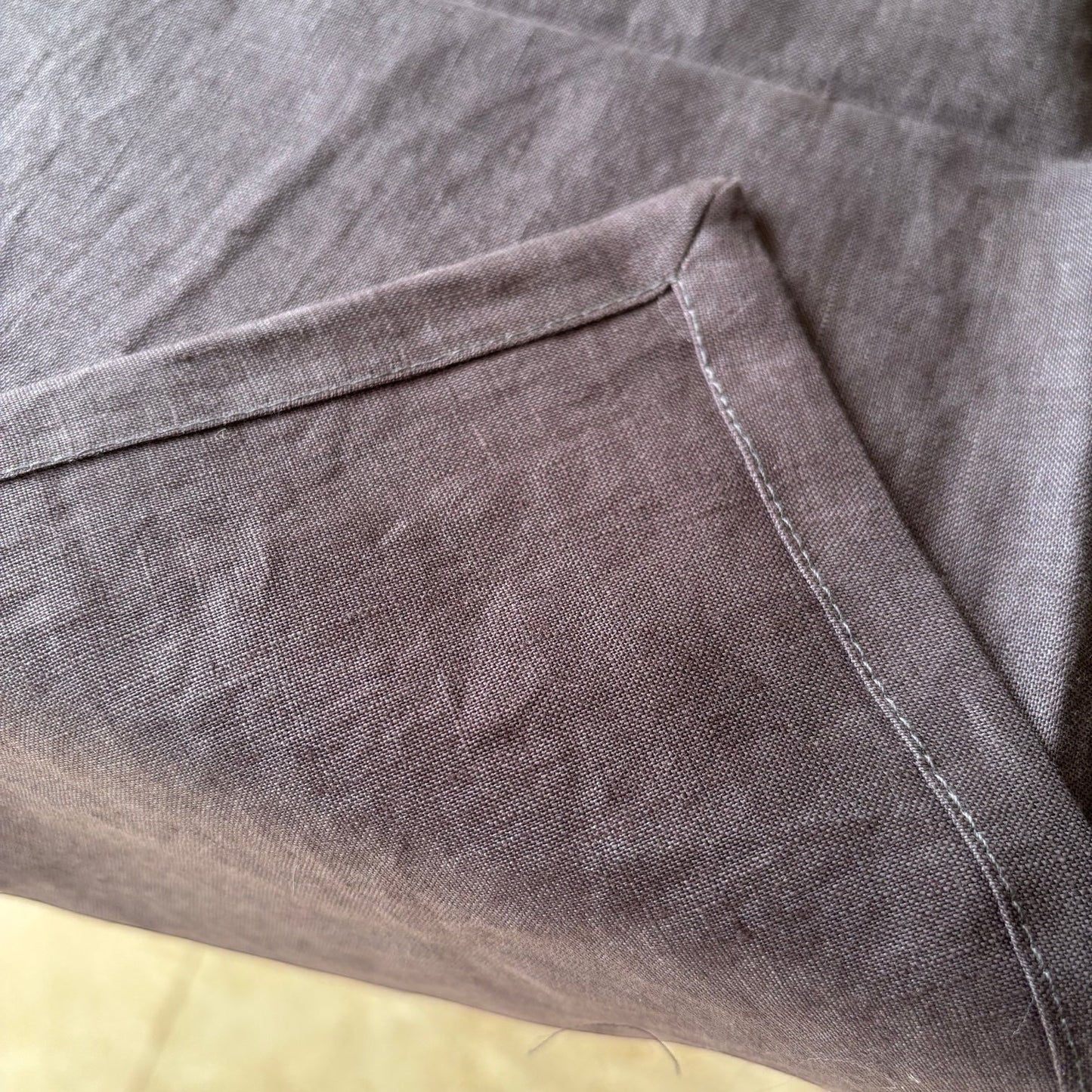 Eclectic charcoal 100% linen table runner with detailed stitched corner edging and natural fabric texture