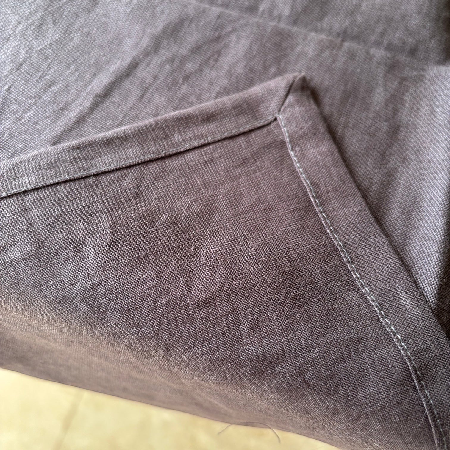 Eclectic charcoal 100% linen table runner with detailed stitched corner edging and natural fabric texture