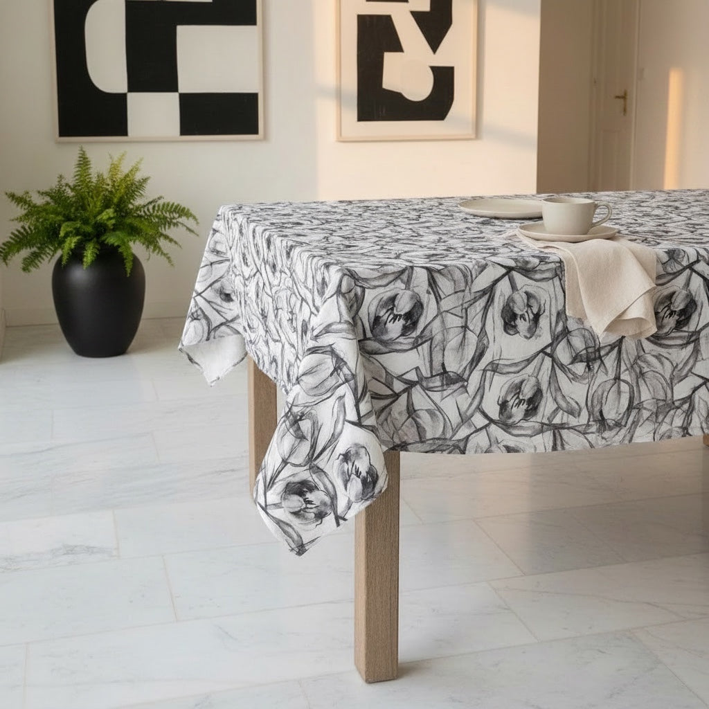 Eclectic charcoal tulip print polyslub tablecloth on a wooden dining table in a modern room