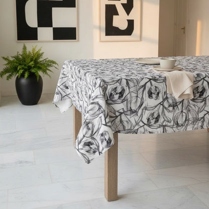 Eclectic charcoal tulip print polyslub tablecloth on a wooden dining table in a modern room