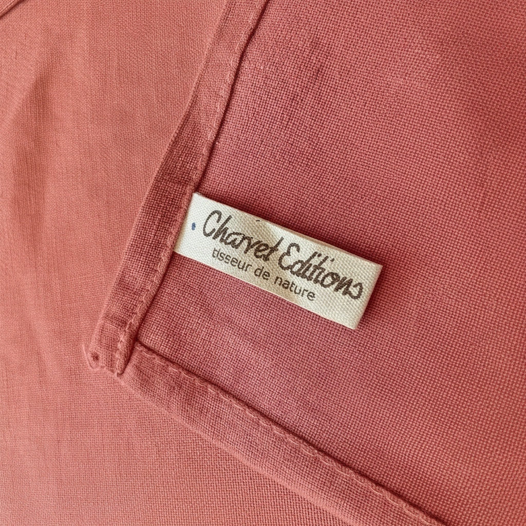 Eclectic Charvet Editions terracotta linen tablecloth featuring a woven fabric texture and brand label detail.