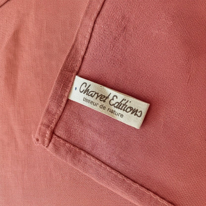 Eclectic Charvet Editions terracotta linen tablecloth featuring a woven fabric texture and brand label detail.