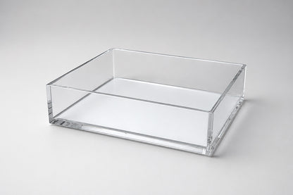Eclectic clear acrylic rectangular display tray with a mirrored base and polished edges for home decor.