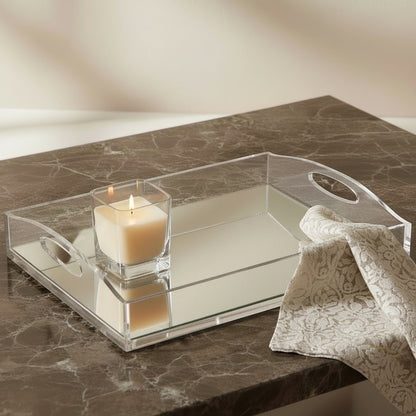 Eclectic clear acrylic gallery tray with a mirrored base, styled with a lit candle and lace cloth on a marble surface.