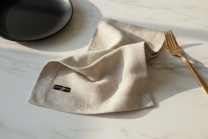 Eclectic Daiva Lino natural stonewashed linen napkin with a delicate tonal scroll pattern on a marble table