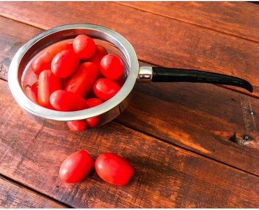 Eclectic Diana Carmichael Impondo Zulu pewter dish with black resin horn handle filled with red cherry tomatoes
