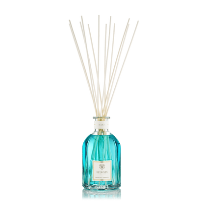 Eclectic Dr Vranjes Acqua reed diffuser in a blue glass bottle with natural sticks against a black background.