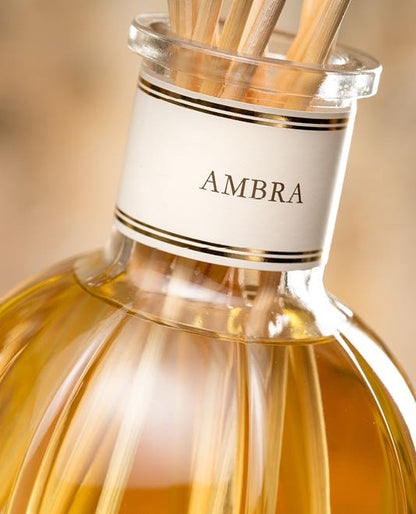 Eclectic Dr Vranjes Ambra diffuser refill in a glass bottle with reed sticks, featuring a warm amber fragrance.