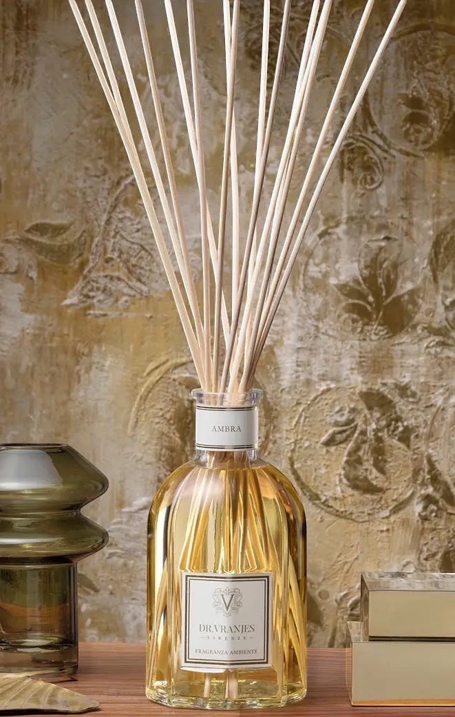 Eclectic Dr. Vranjes Ambra 500ml room diffuser with natural bamboo reeds in a glass bottle on a wooden surface