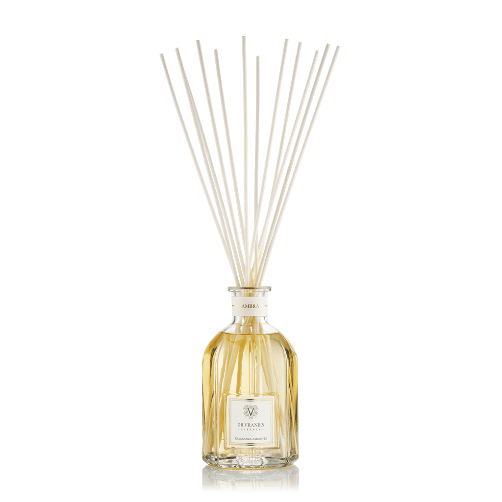 Eclectic Dr Vranjes Ambra reed diffuser in a classic glass bottle with natural rattan sticks against a black background