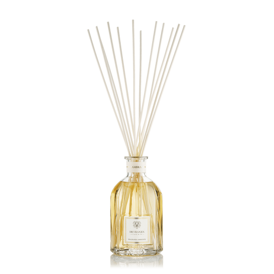 Eclectic Dr Vranjes Ambra reed diffuser in a classic glass bottle with natural rattan sticks against a black background