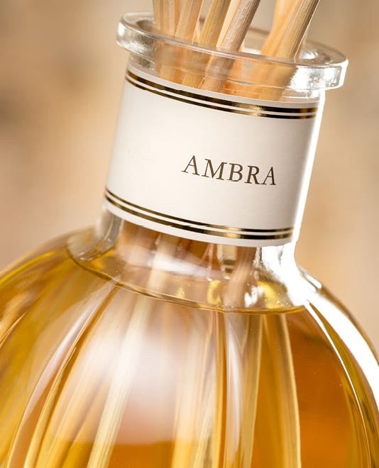 Eclectic Dr Vranjes Ambra reed diffuser in a classic glass bottle with natural wooden sticks for home fragrance.