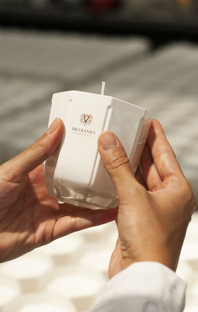 Eclectic Dr Vranjes Ginger Lime scented candle in a pearl-coloured glass vase held in hands.