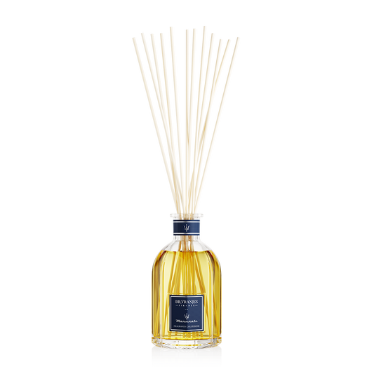Eclectic Dr Vranjes Maserati reed diffuser in a glass bottle with natural sticks against a black background