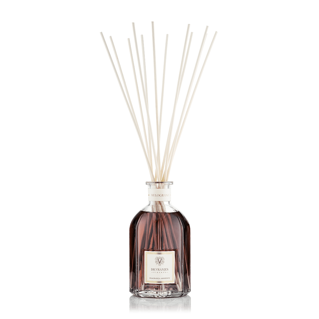 Eclectic Dr Vranjes Melograno reed diffuser in a glass bottle with natural sticks against a black background