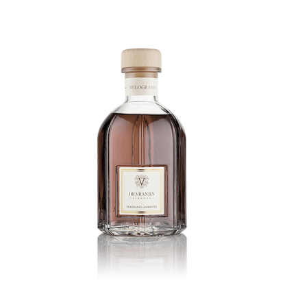 Eclectic Dr Vranjes Melograno reed diffuser in a clear glass bottle with a wooden cap against a black background.