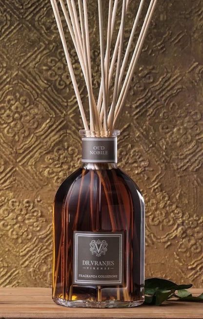 Eclectic Dr. Vranjes Oud Nobile 500ml glass fragrance diffuser with natural bamboo reeds against a textured gold wall