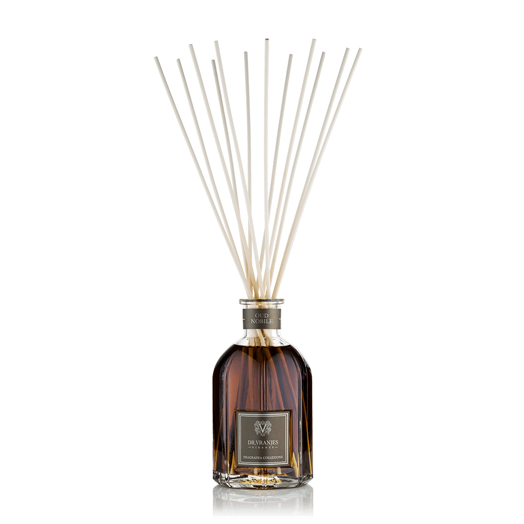 Eclectic Dr Vranjes Oud Nobile reed diffuser in a glass bottle with natural sticks against a black background.