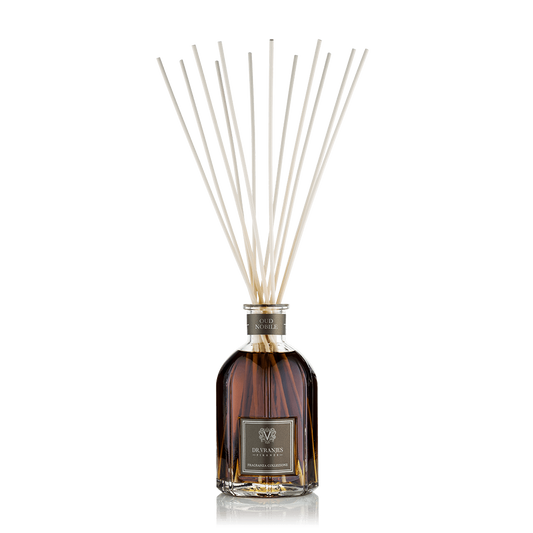 Eclectic Dr Vranjes Oud Nobile reed diffuser in a glass bottle with natural sticks against a black background.