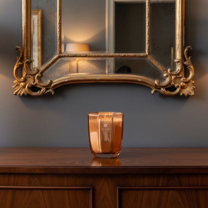 Eclectic Dr. Vranjes Oud Nobile scented candle in a glass holder on a wooden console table beneath an ornate mirror.