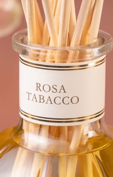 Eclectic Dr Vranjes Rosa Tabacco diffuser refill bottle with natural reeds against a warm rose-toned background.