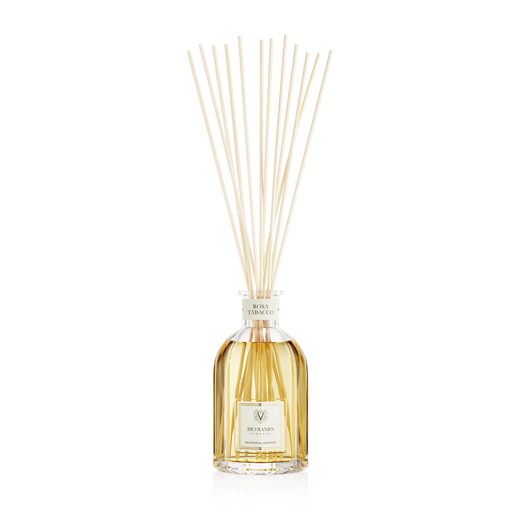 Eclectic Dr Vranjes Rosa Tabacco reed diffuser in a glass bottle with natural sticks against a black background.