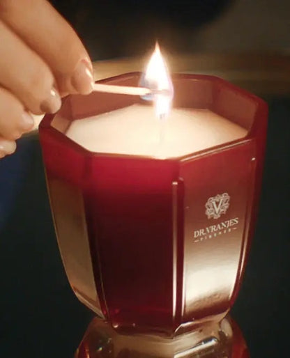 Eclectic Dr. Vranjes Rosso Nobile scented candle in a ruby-red glass vessel being lit with a match