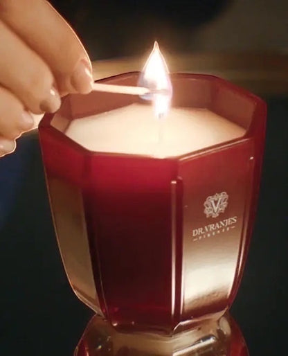 Eclectic Dr. Vranjes Rosso Nobile scented candle in a ruby-red glass vessel being lit with a match.