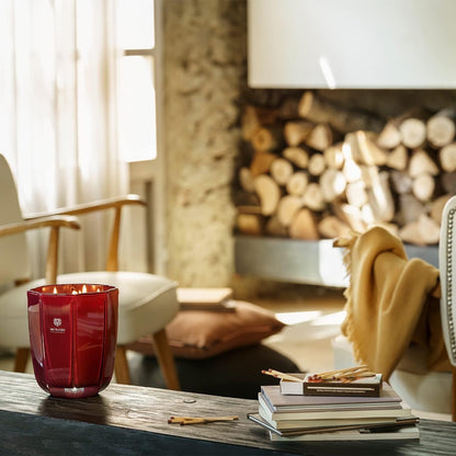 Eclectic Dr. Vranjes Rosso Nobile scented candle in a tourmaline glass vase, lit on a rustic wooden table.