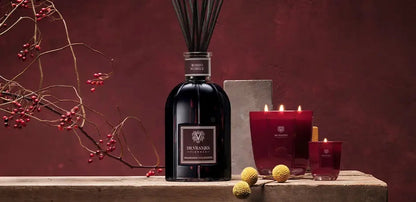 Eclectic Dr. Vranjes Rosso Nobile luxury gift set featuring a ruby-red reed diffuser and scented candles on a wooden table.