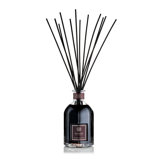 Eclectic Dr Vranjes Rosso Nobile reed diffuser in a glass bottle with black fragrance sticks against a black background.