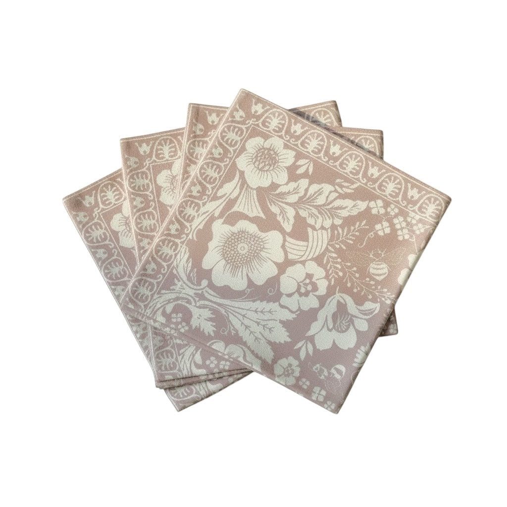 Eclectic set of 4 dusty pink napkins featuring a white botanical floral print and a linen-look polyester finish.
