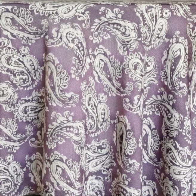 Eclectic round tablecloth in dusty plum with a white paisley pattern and a textured linen-look finish.